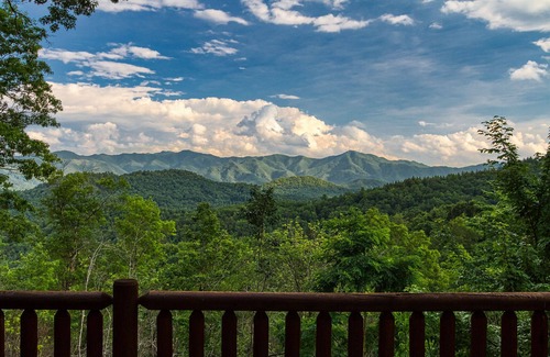 Almond Cabin | Antler Ridge - a stunning log cabin with spacious deck equipped with outdoor fireplace, hot tub, and scenic mountain views!