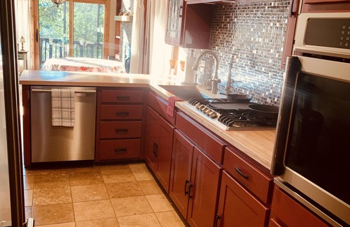 Springdale House | Lakeside house with fireplace, deck, and a fenced backyard with firepit.