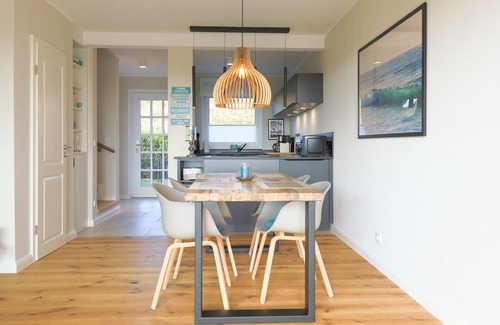 Rantum House | The walls are painted in a warm beige and decorated with cool pictures.