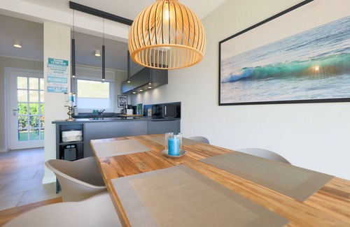 Rantum House | The walls are painted in a warm beige and decorated with cool pictures.