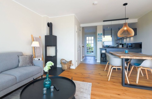 Rantum House | The walls are painted in a warm beige and decorated with cool pictures.