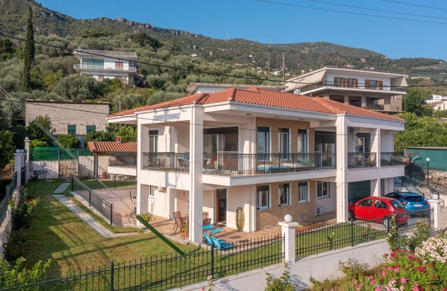 εξοχική ισόγεια κατοικία σε κήπο με γκαζόν με θέα θάλασσα και καταπράσινο λόφο