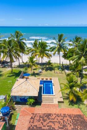 Casa completo com grande piscina sob coqueiros, pe na areia