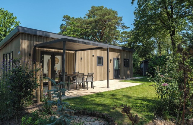 Enjoy a luxurious holiday home for 5 persons in the wooded nature of the Veluwe, complete with modern amenities, air conditioning, and a stylish pergola for optimal comfort.