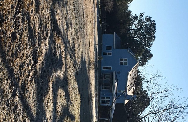 Farm home with horses and cattle on site.