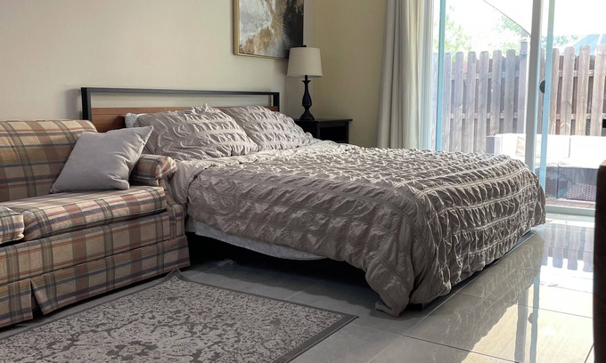 Lake Worth Apartment | Cozy room with pool and patio.