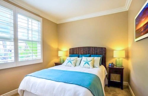 Beach Barber Tract House | Two-story house with lush, enclosed backyard for outdoor living & beach gear