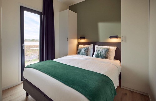 Lattrop House | This holiday home for six persons has a spacious living room with an open kitchen, three bedrooms and a spacious patio.